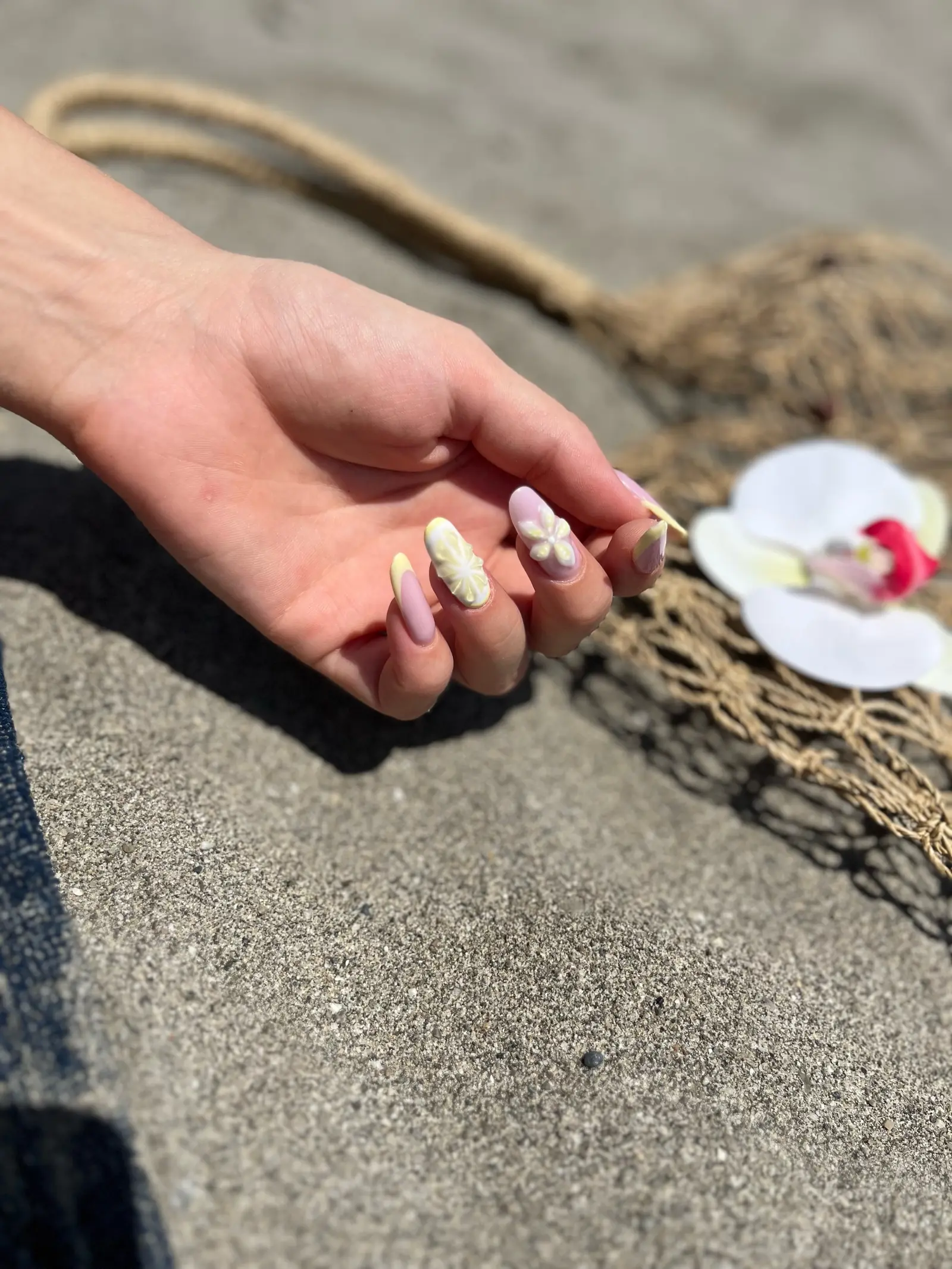 Bright mixed-colour almond nail art photographed outdoors