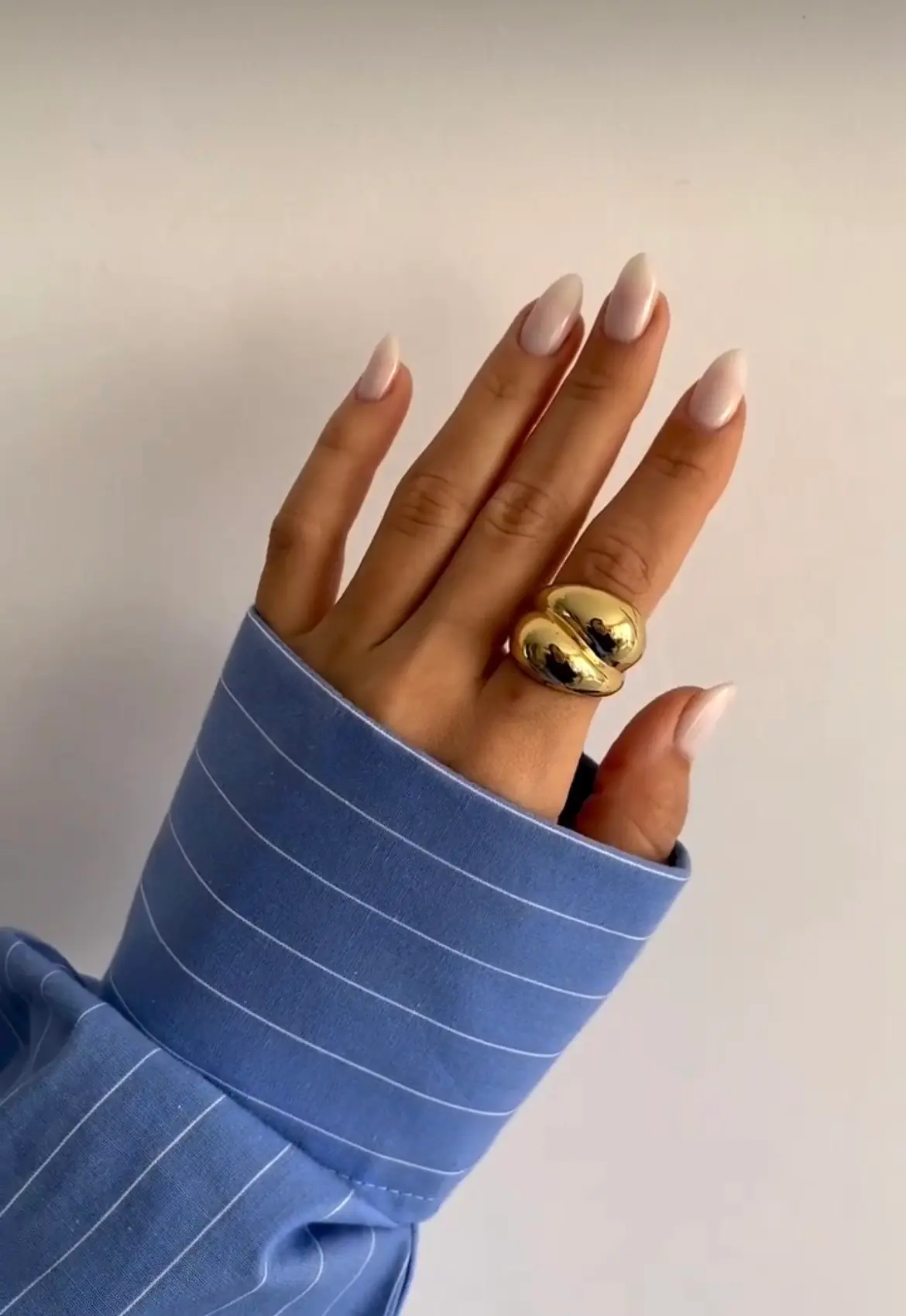 Long glossy nude almond nails with warm neutral tones